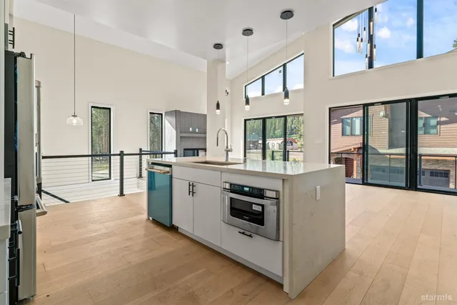 a large white kitchen with stainless steel appliances kitchen island granite countertop a large counter top and white cabinets