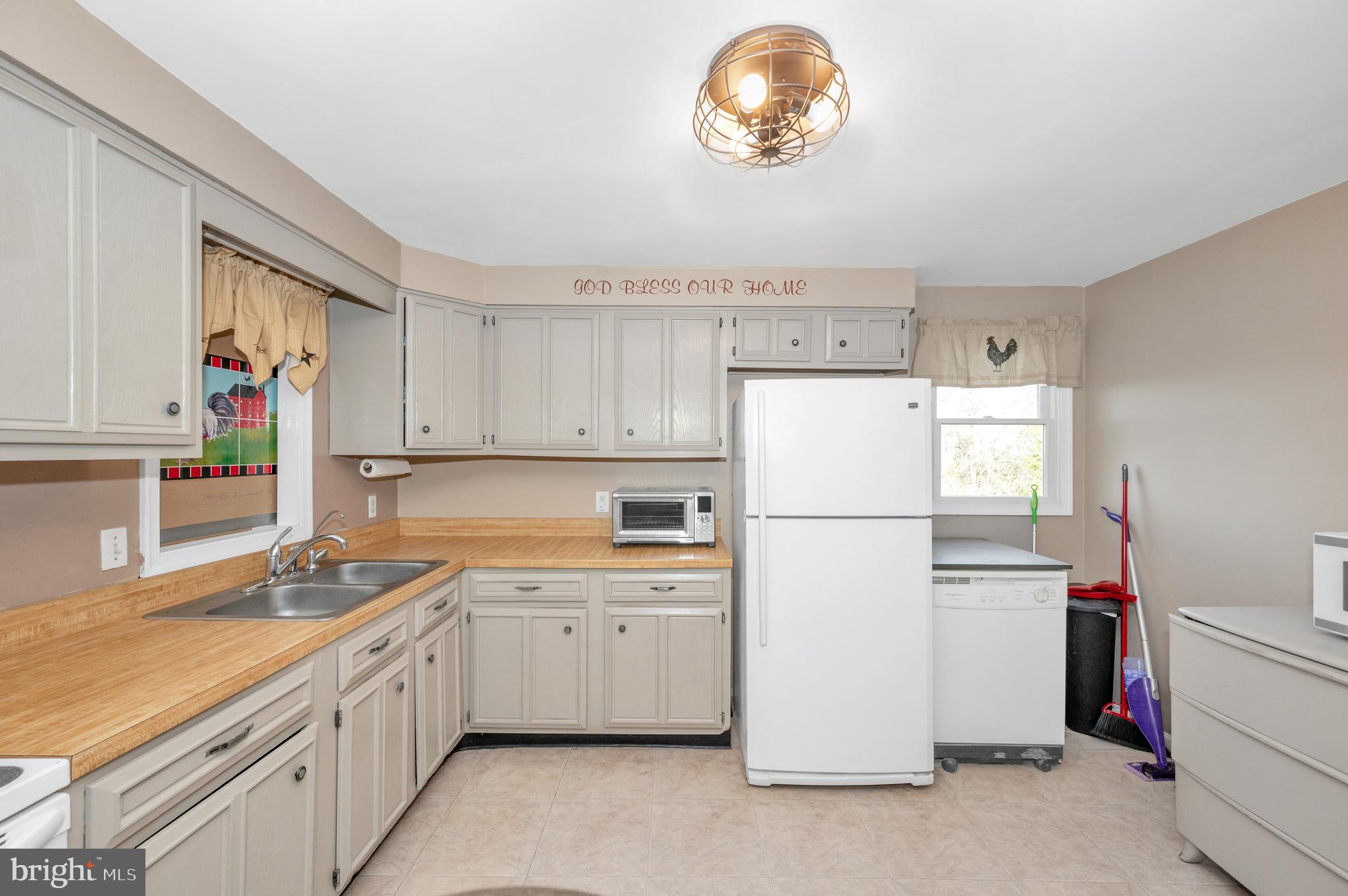 13411 Rabbit Run Terrace Union Bridge, MD 21791 - Photo 8 of 47 a kitchen with a refrigerator a sink and dishwasher with white cabinets