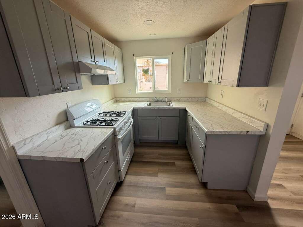 1258 East 15th Street Douglas, AZ 85607 - Photo 5 of 15 a kitchen with a sink stove and cabinets
