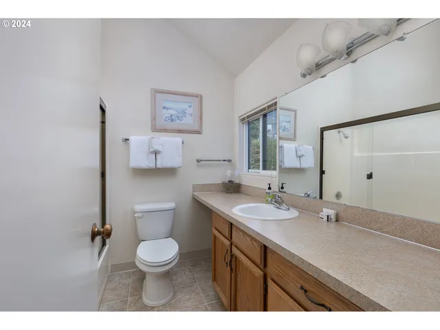 a bathroom with a granite countertop toilet sink a mirror and shower