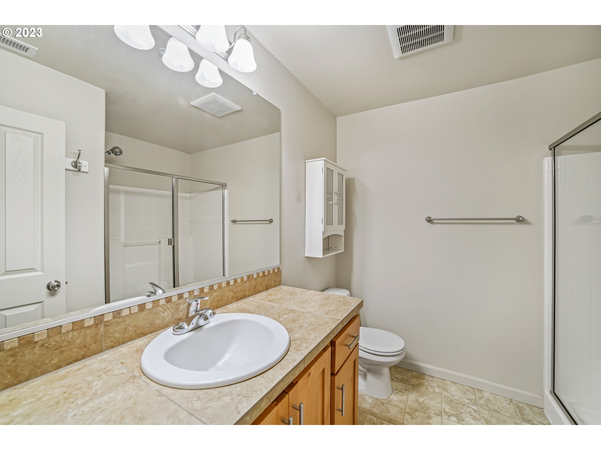 10595 Northeast Cedar Falls Loop Hillsboro, OR 97006 - Photo 15 of 27 a bathroom with a granite countertop sink toilet a mirror and shower