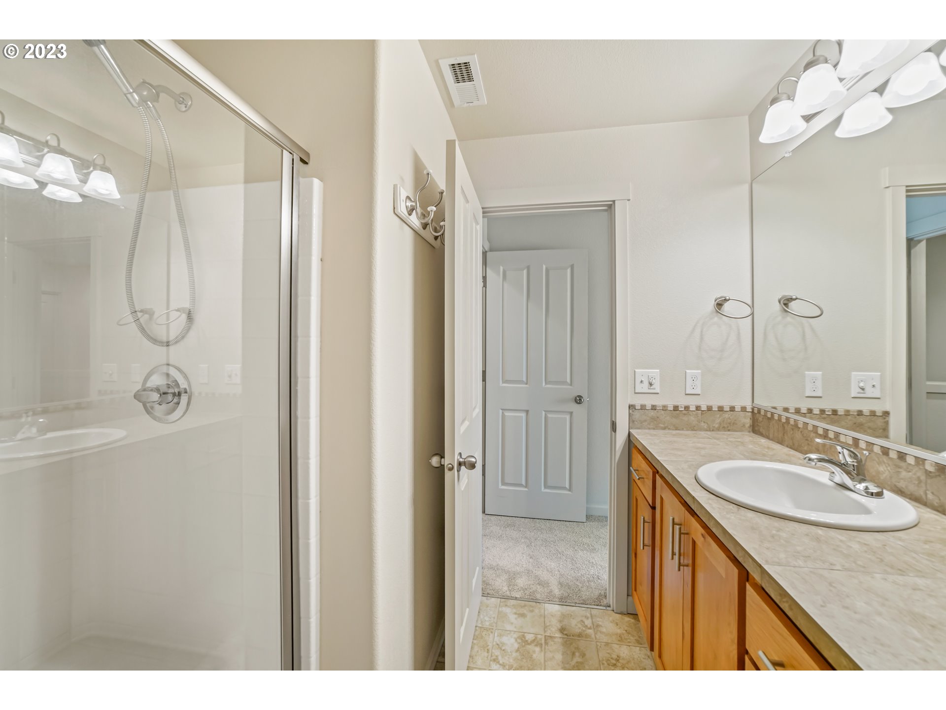 10595 Northeast Cedar Falls Loop Hillsboro, OR 97006 - Photo 16 of 27 a bathroom with a granite countertop sink a mirror and a shower