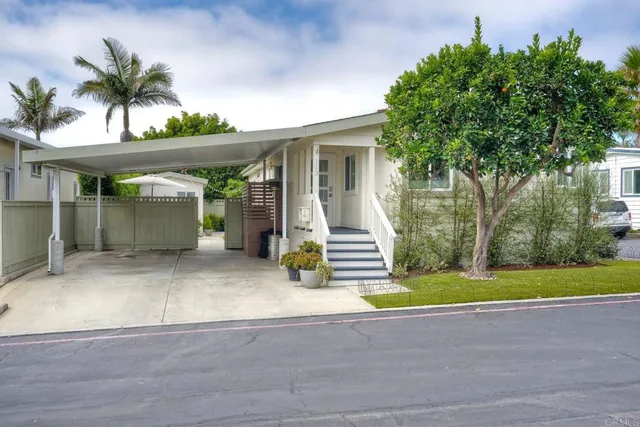a view of a house with a yard and potted plants