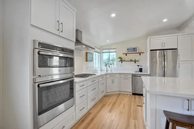 a kitchen with white cabinets and stainless steel appliances