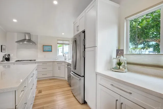a kitchen with white cabinets and refrigerator