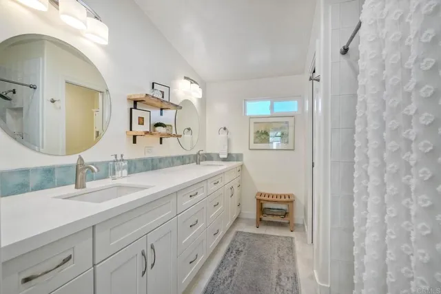 a en suite bathroom with a double vanity sink and a mirror