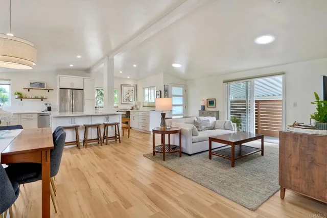 a living room with lots of furniture and kitchen view