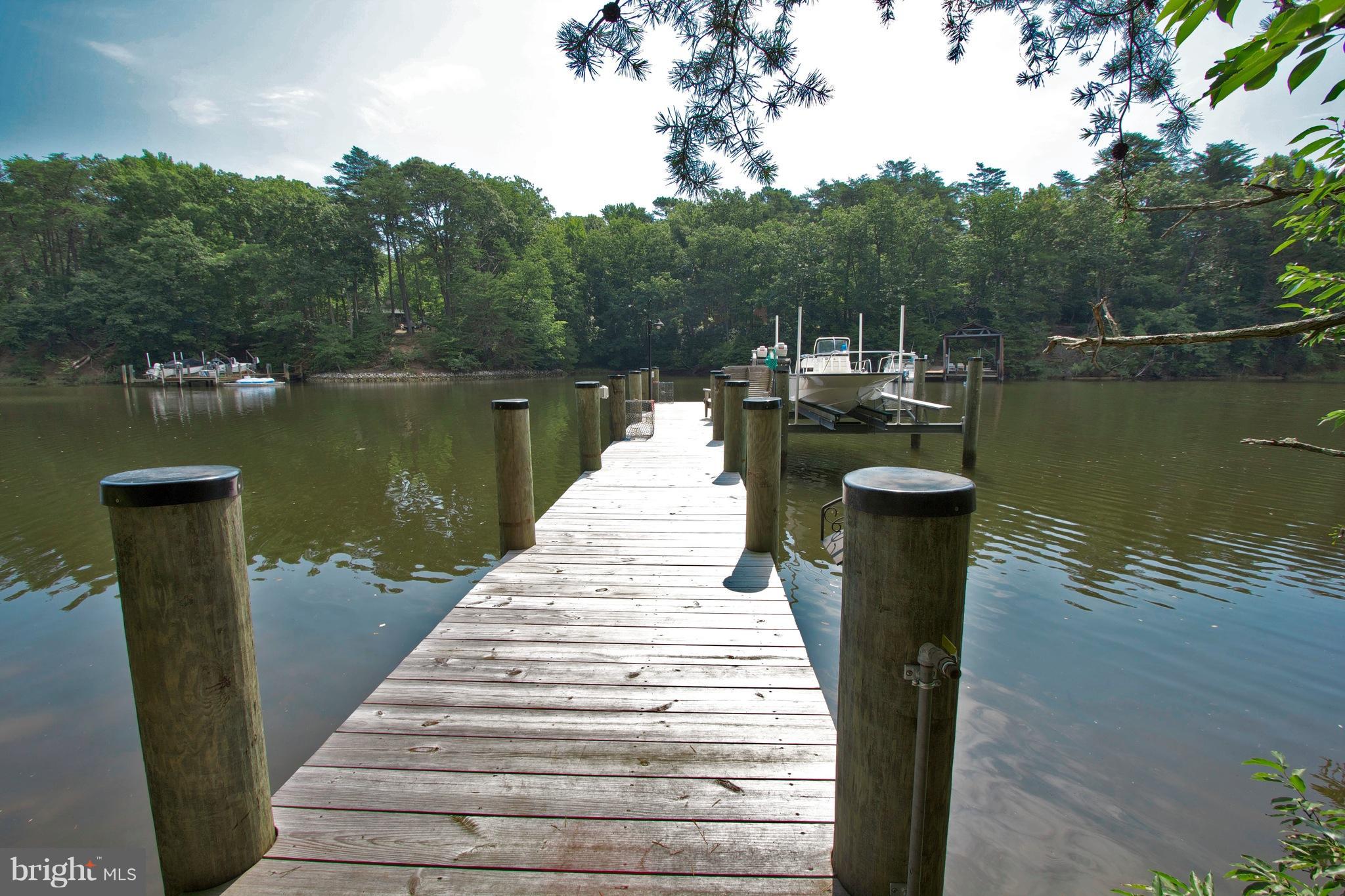 13422 Olivet Road Lusby, MD 20657 - Photo 17 of 23 a wooden pier with boats in a lake