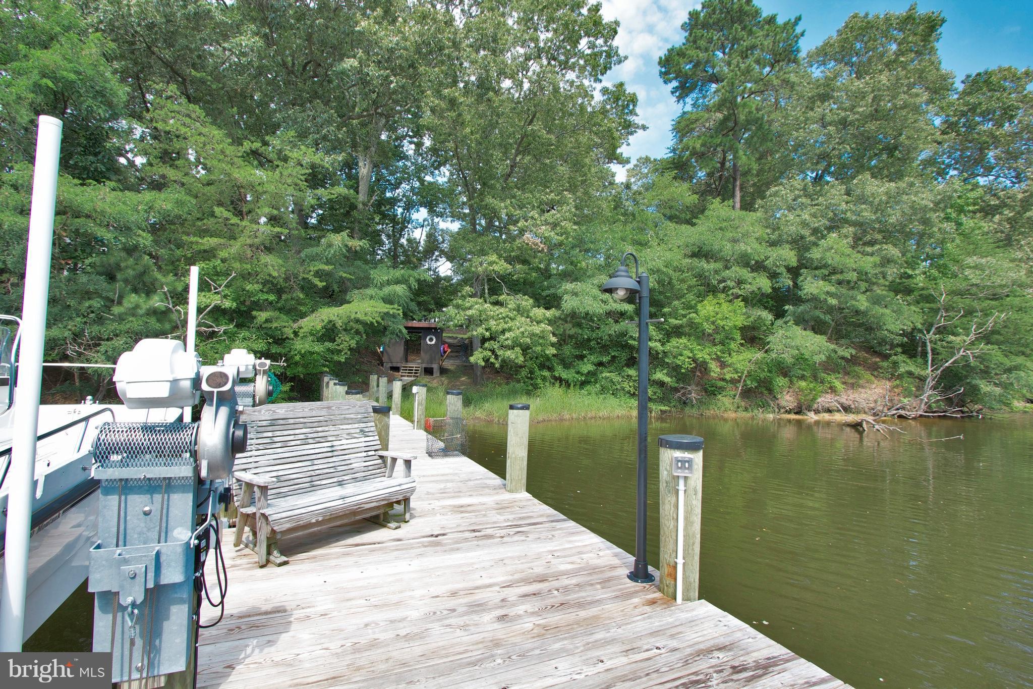 13422 Olivet Road Lusby, MD 20657 - Photo 18 of 23 a wooden bench sitting next to a lake