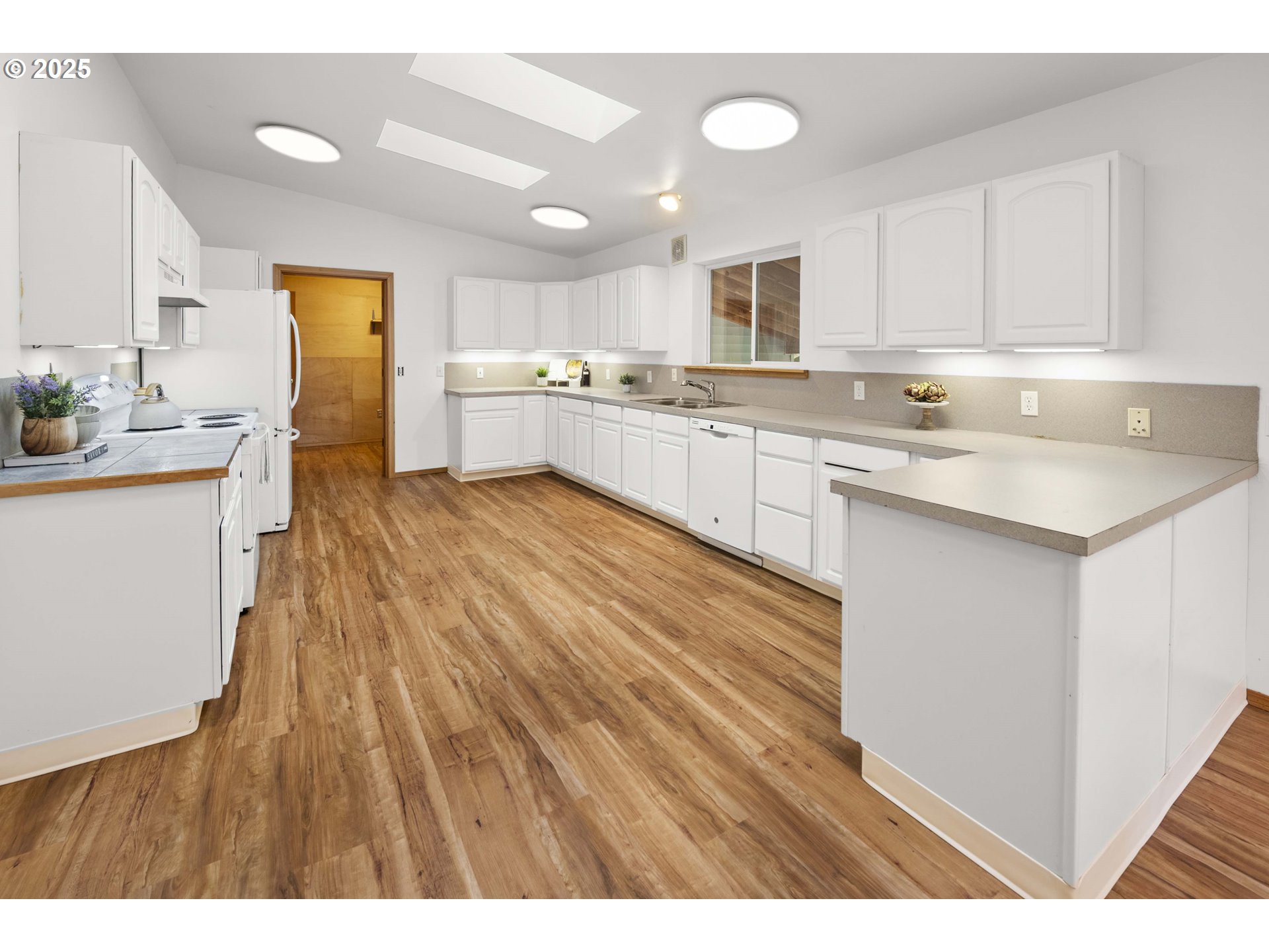 89022 Welch Road Astoria, OR 97103 - Photo 12 of 42 a large white kitchen with wooden floors and stainless steel appliances