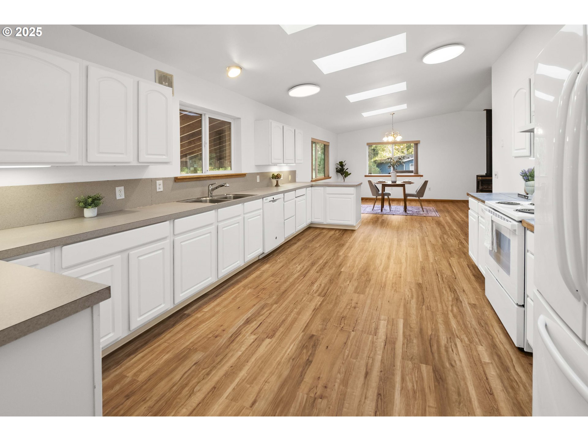 89022 Welch Road Astoria, OR 97103 - Photo 16 of 42 a large white kitchen with wooden floors and stainless steel appliances