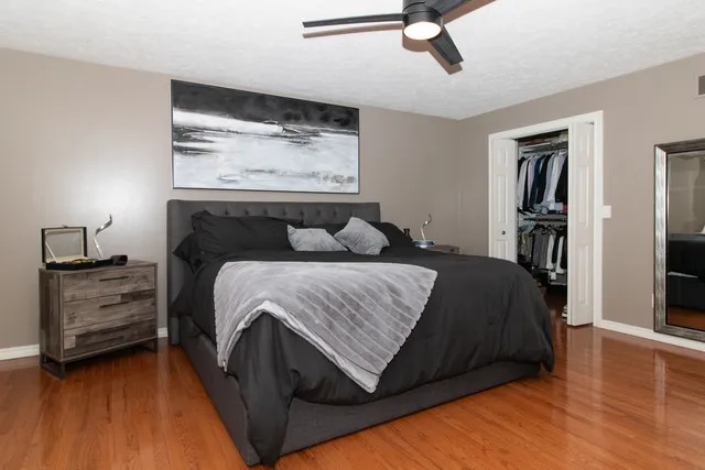 a bedroom with a bed and a flat tv screen on the dresser