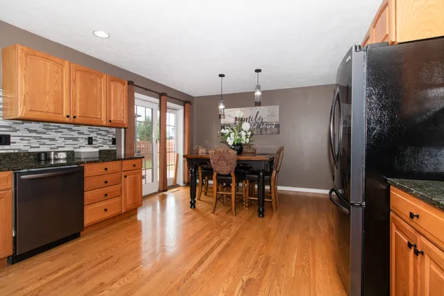 a dining room filled chandelier and wooden furniture