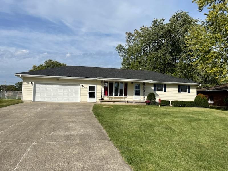 a front view of a house with a garden and trees