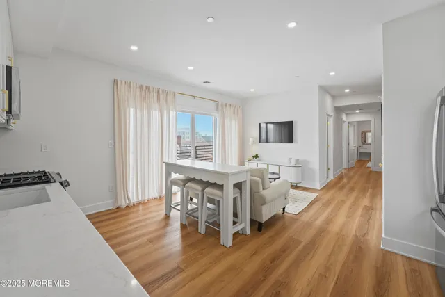 a living room with furniture a wooden floor and next to a window