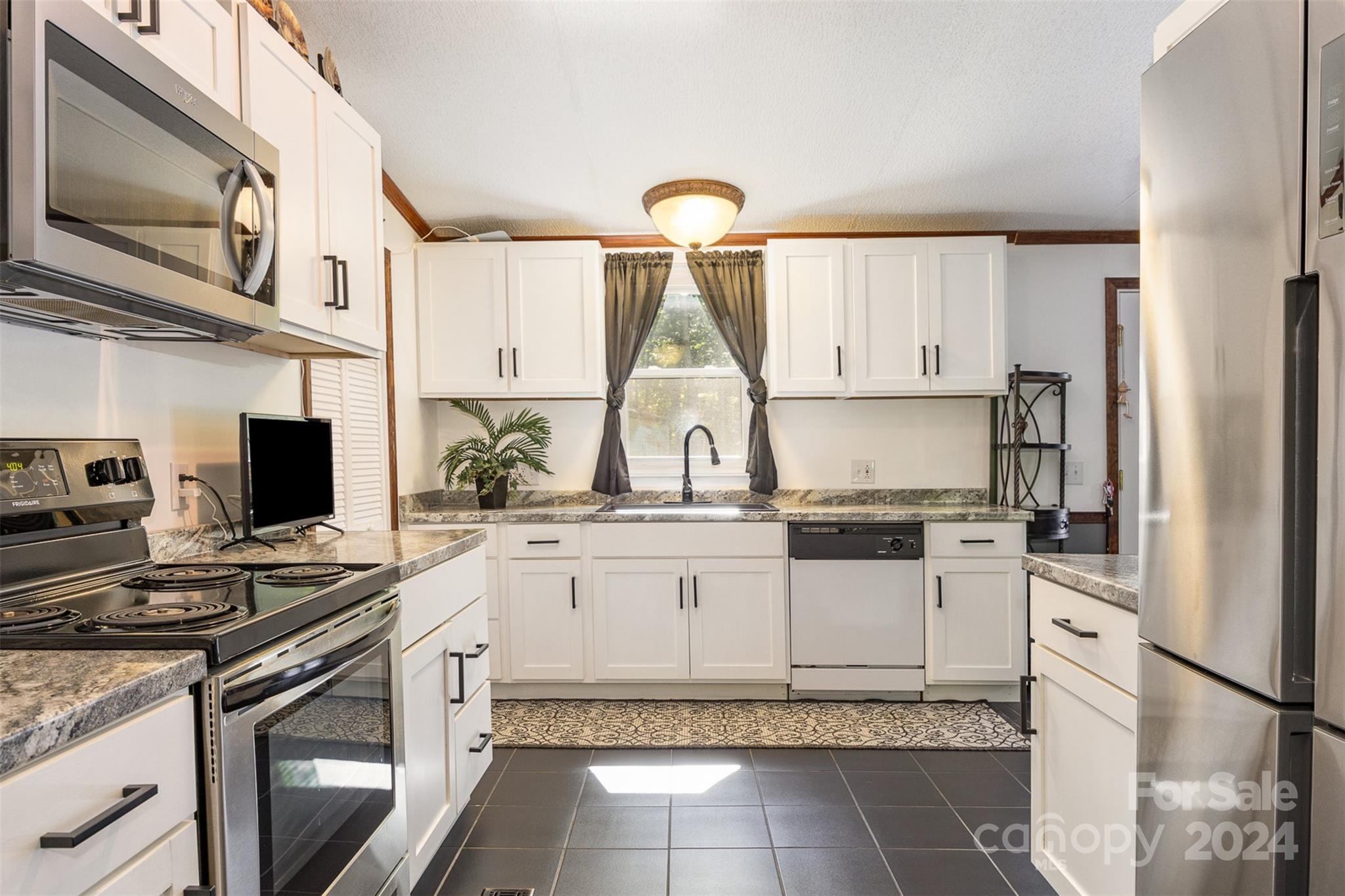 417 Old Tulip Farm Road Salisbury, NC 28147 - Photo 11 of 35 a kitchen with stainless steel appliances granite countertop a stove sink and cabinets
