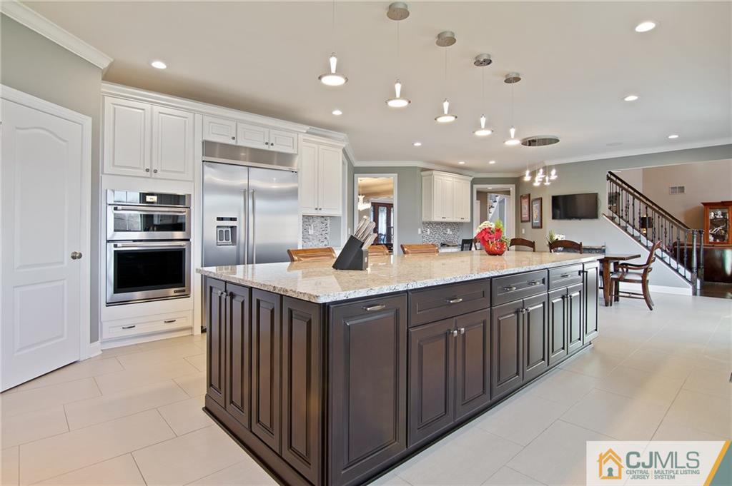 25 Preakness Drive Monroe Township, NJ 08831 - Photo 7 of 48 a kitchen with stainless steel appliances kitchen island granite countertop a sink and cabinets