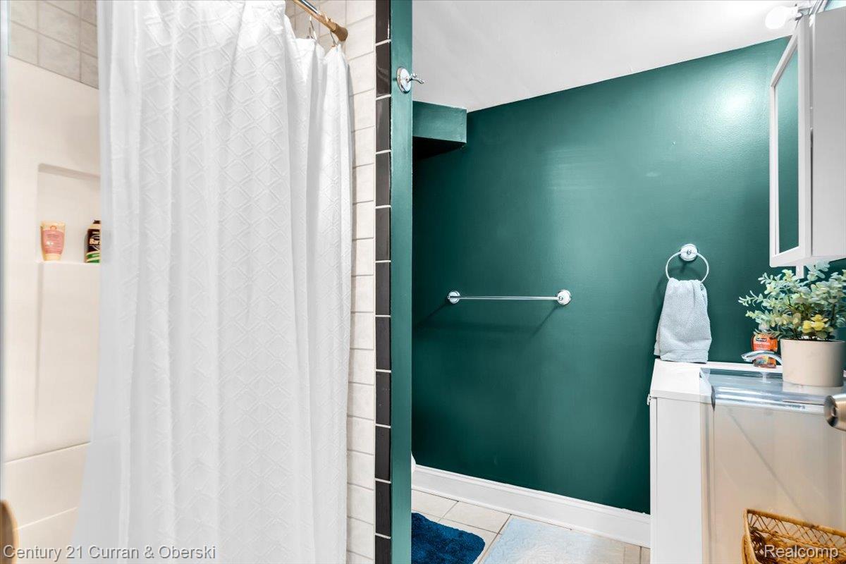 21439 Hall Road Trenton, MI 48183 - Photo 24 of 35 Bathroom featuring a walk in shower with built-in shelving, white subway tile, and dark green painted walls