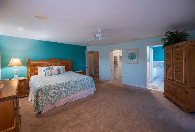 a bedroom with a bed and a potted plant on table