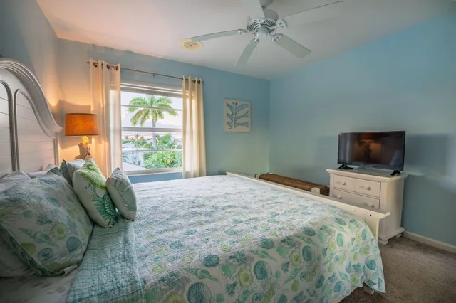 a bedroom with a bed a television and a window