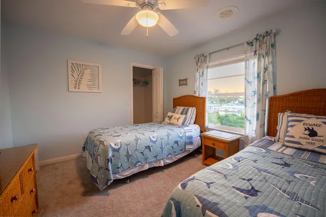 a bedroom with two beds and a large window