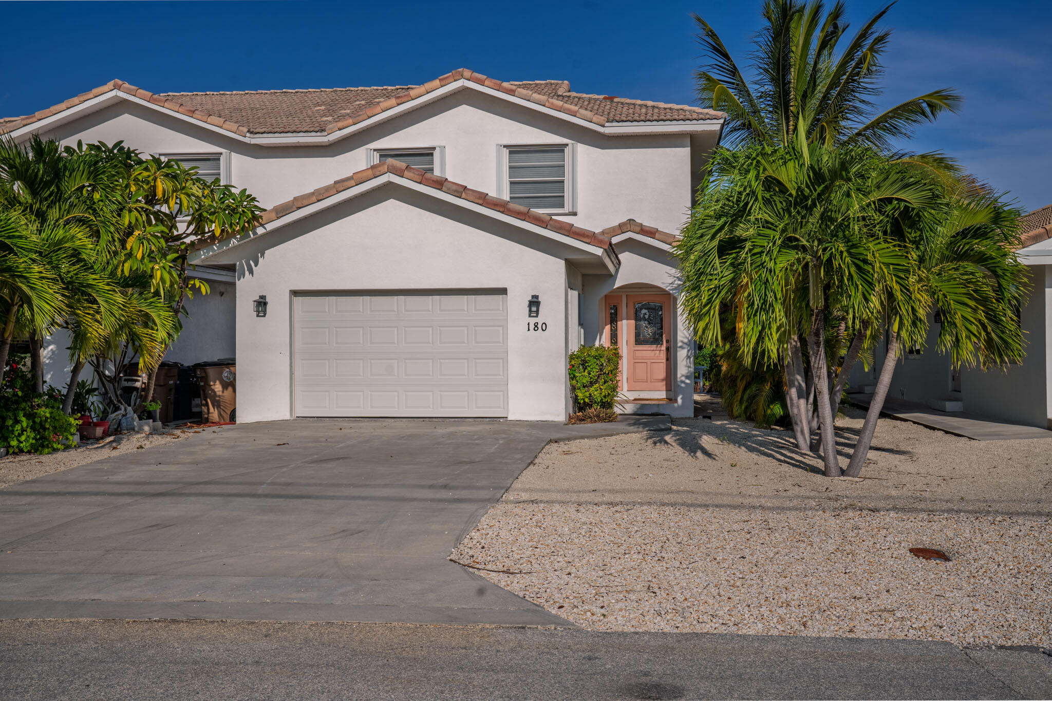 180 9th Street Key Colony Beach, FL 33051 - Photo 31 of 38 a view of a white house with a small yard and palm trees