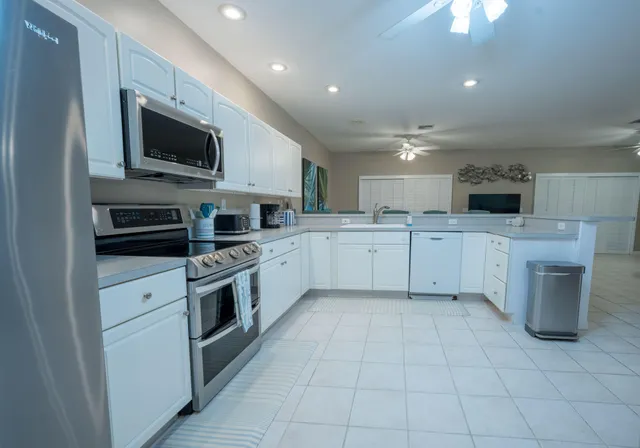 a large kitchen with stainless steel appliances granite countertop a sink and dishwasher a stove top oven with a dishwasher