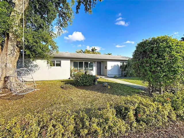 a view of a house with backyard and tree