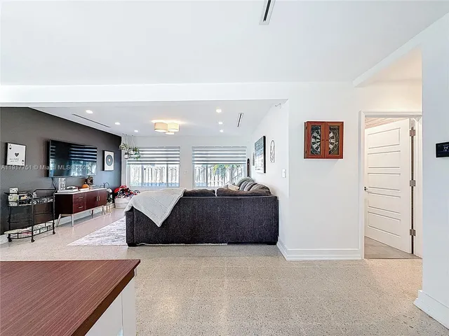 a living room with furniture a large window and a flat screen tv