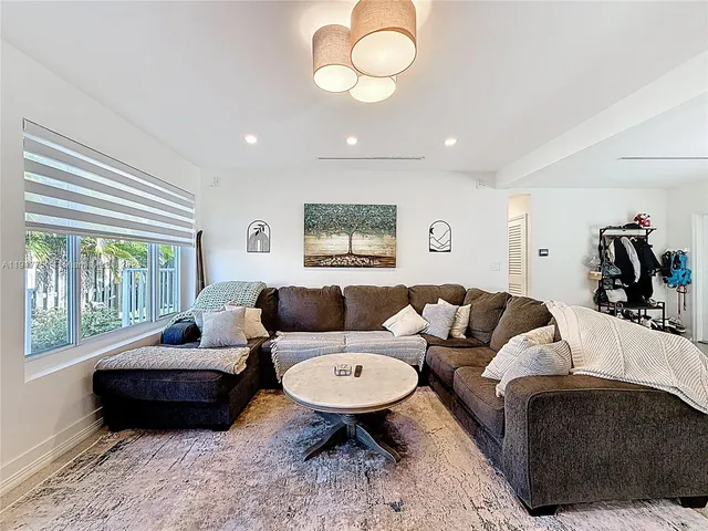 a view of a kitchen with kitchen island a sink wooden floor and a large window