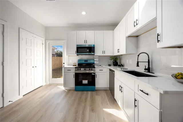 a kitchen with granite countertop a sink and steel appliances