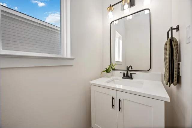 a bathroom with a sink vanity and a mirror