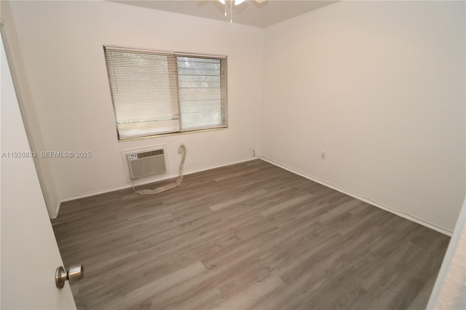 777 Northeast 85th Street, Unit 3 Miami, FL 33138 - Photo 11 of 21 an empty room with wooden floor and windows