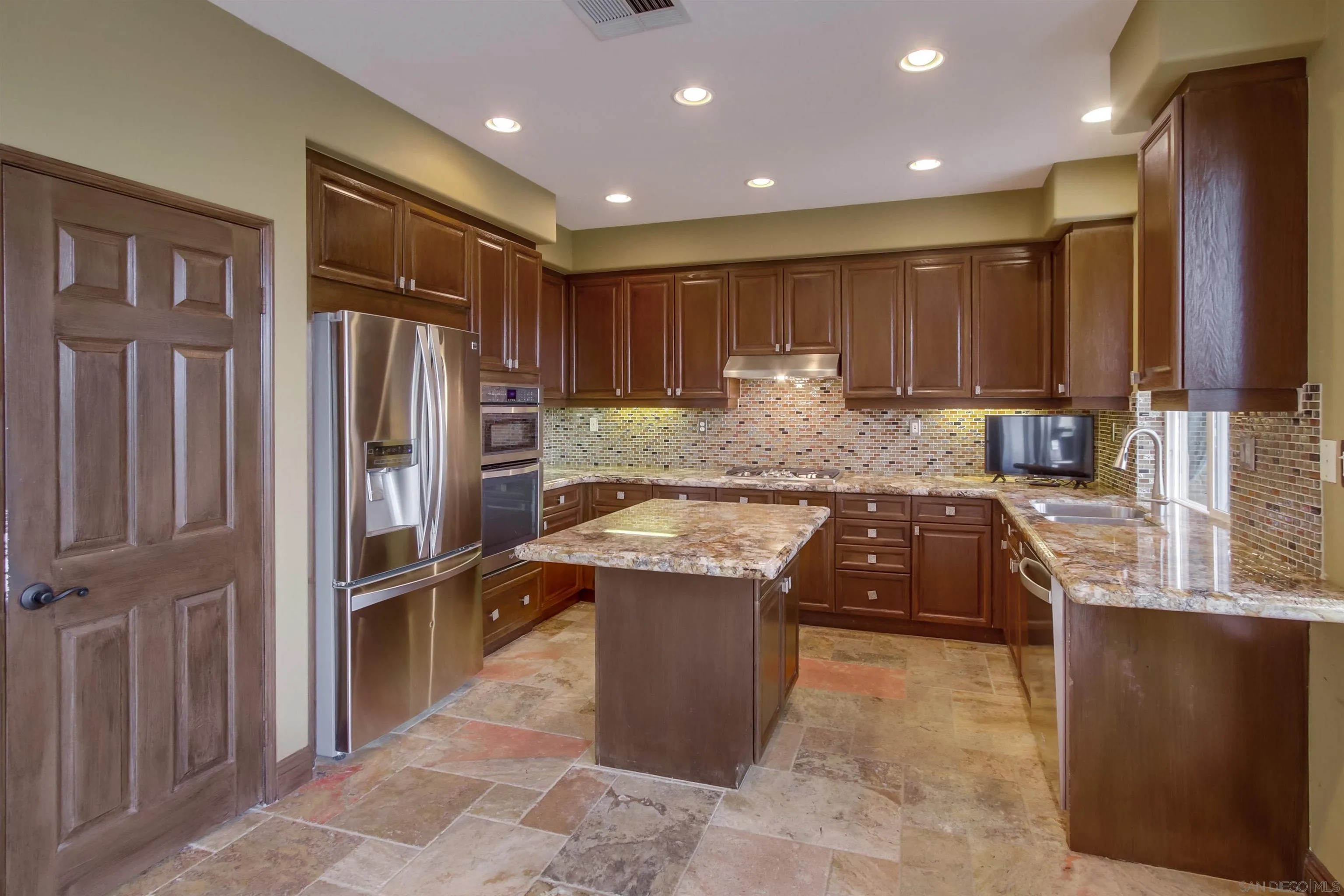 6550 Windward Ridge Way San Diego, CA 92121 - Photo 24 of 64 a kitchen with stainless steel appliances granite countertop a refrigerator a sink and a stove