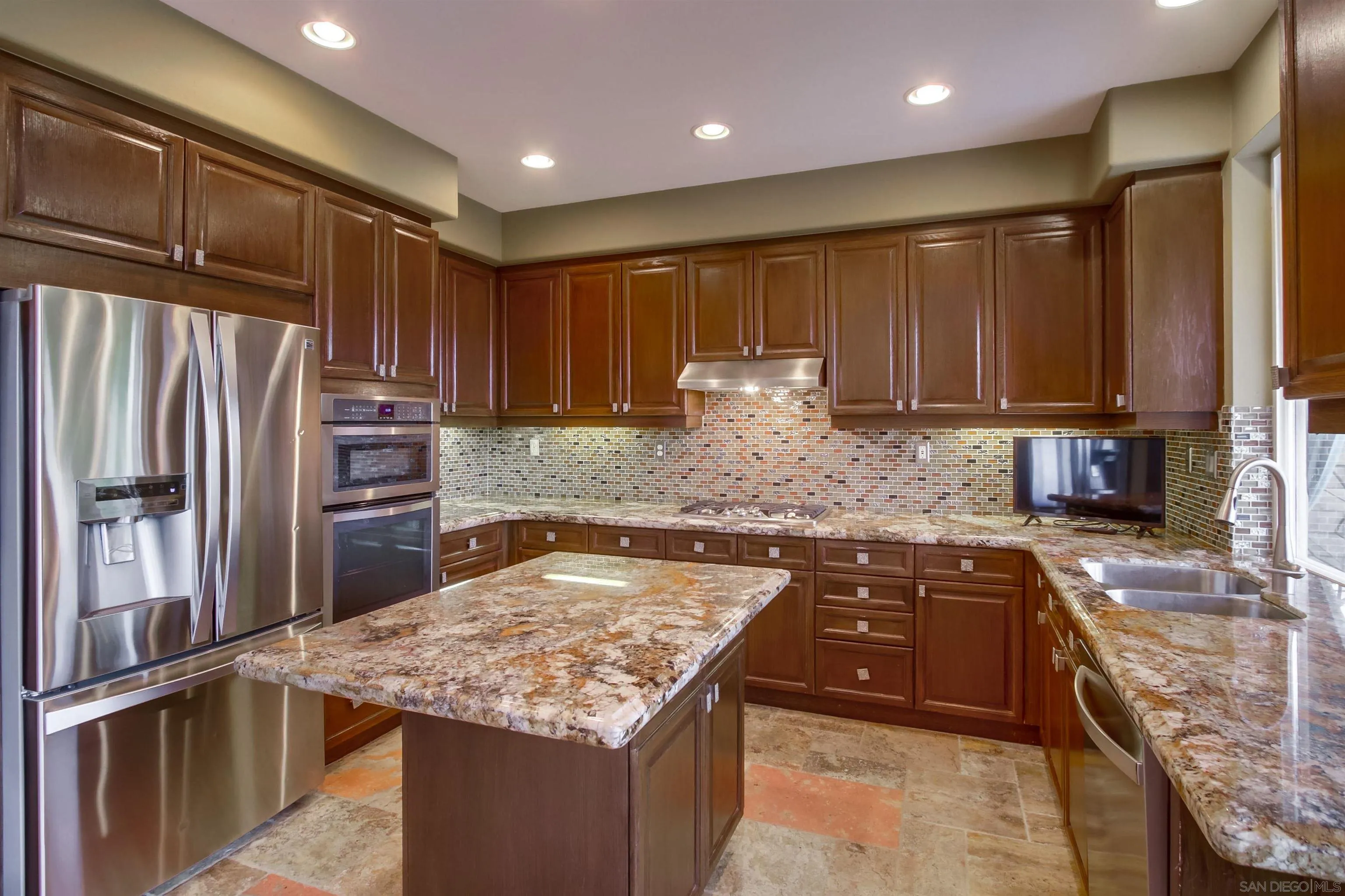 6550 Windward Ridge Way San Diego, CA 92121 - Photo 26 of 64 a kitchen with stainless steel appliances granite countertop a sink stove and refrigerator
