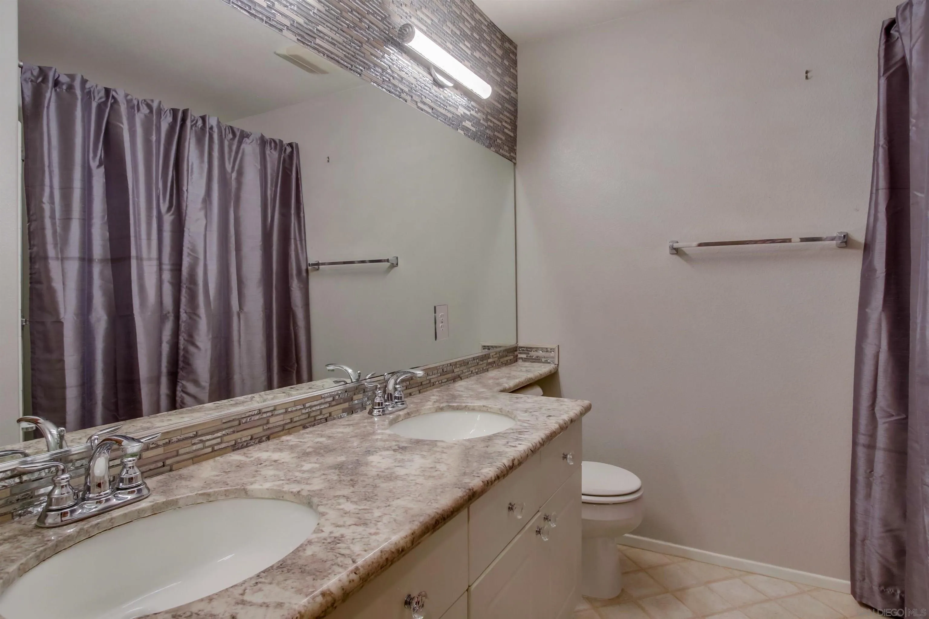 6550 Windward Ridge Way San Diego, CA 92121 - Photo 47 of 64 a bathroom with a granite countertop sink a toilet and a mirror