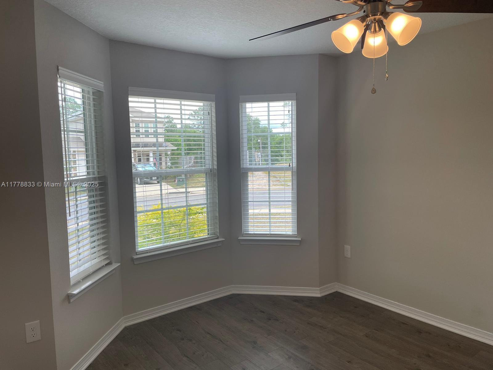 219 Wainwright Drive Crestview, FL 32539 - Photo 15 of 31 an empty room with wooden floor and windows