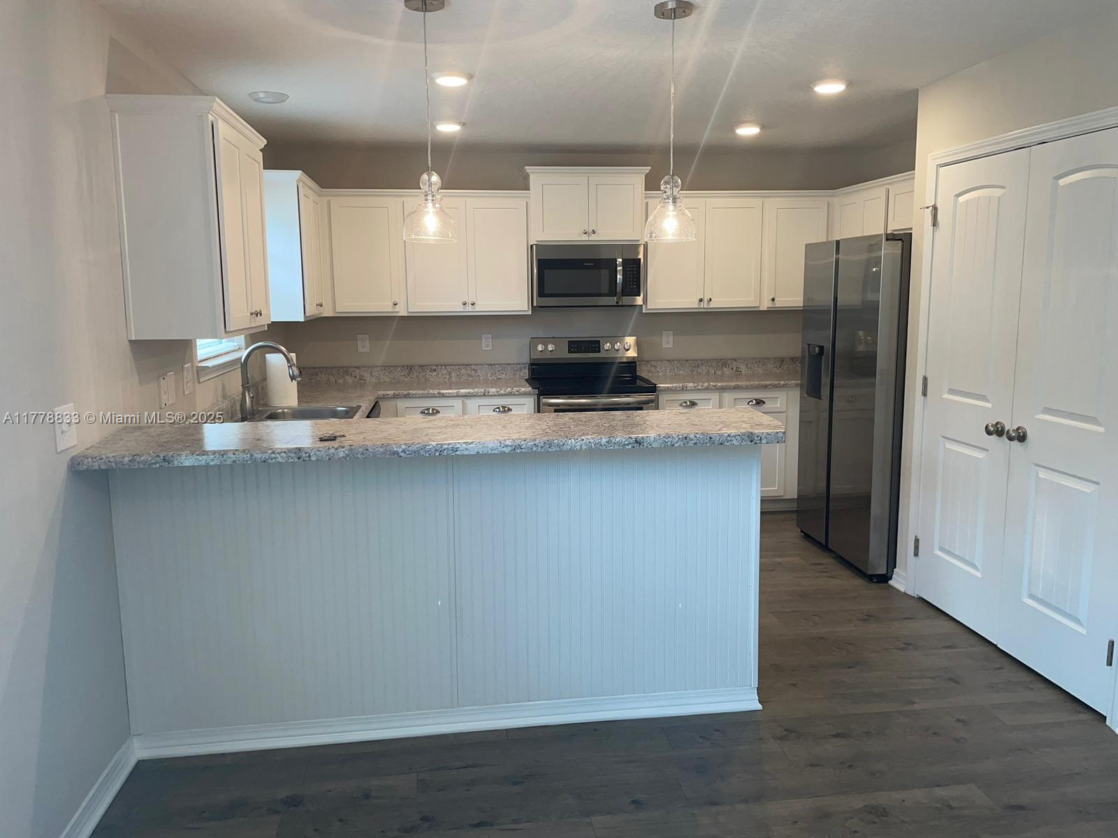 219 Wainwright Drive Crestview, FL 32539 - Photo 28 of 31 a kitchen with stainless steel appliances granite countertop a refrigerator a sink a stove and oven with wooden floor