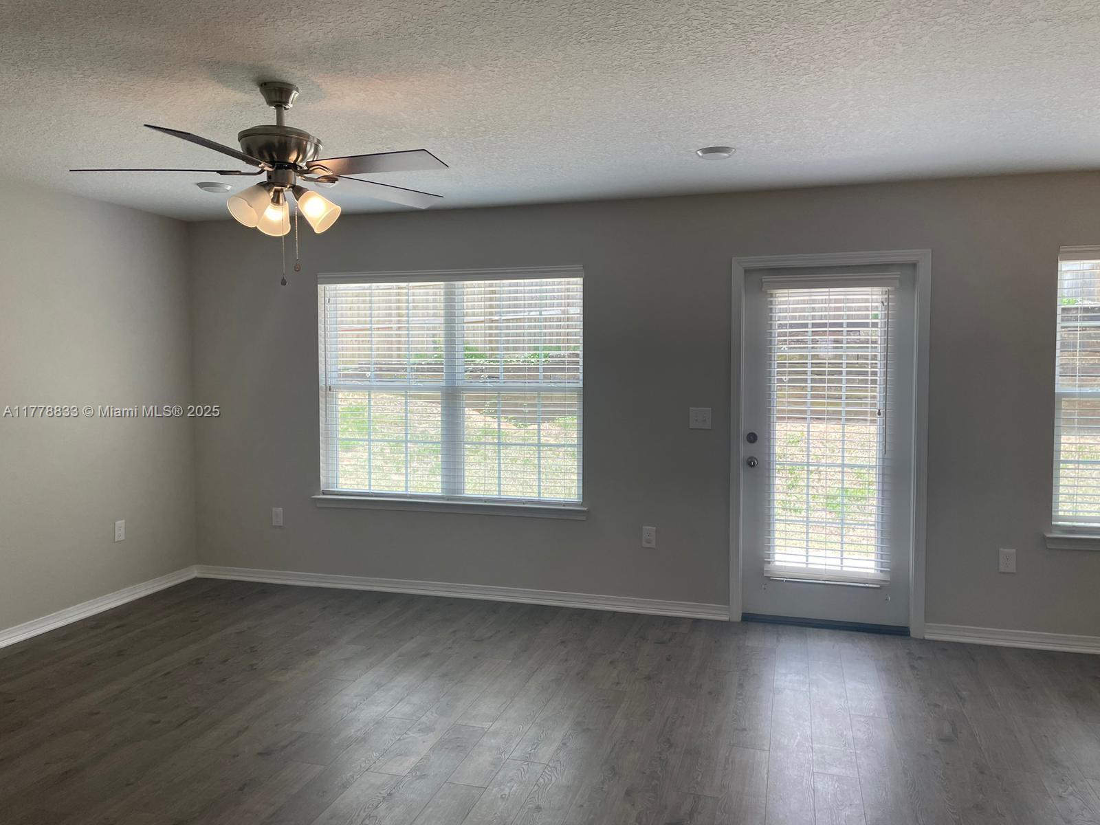 219 Wainwright Drive Crestview, FL 32539 - Photo 9 of 31 a view of an empty room with wooden floor and a window