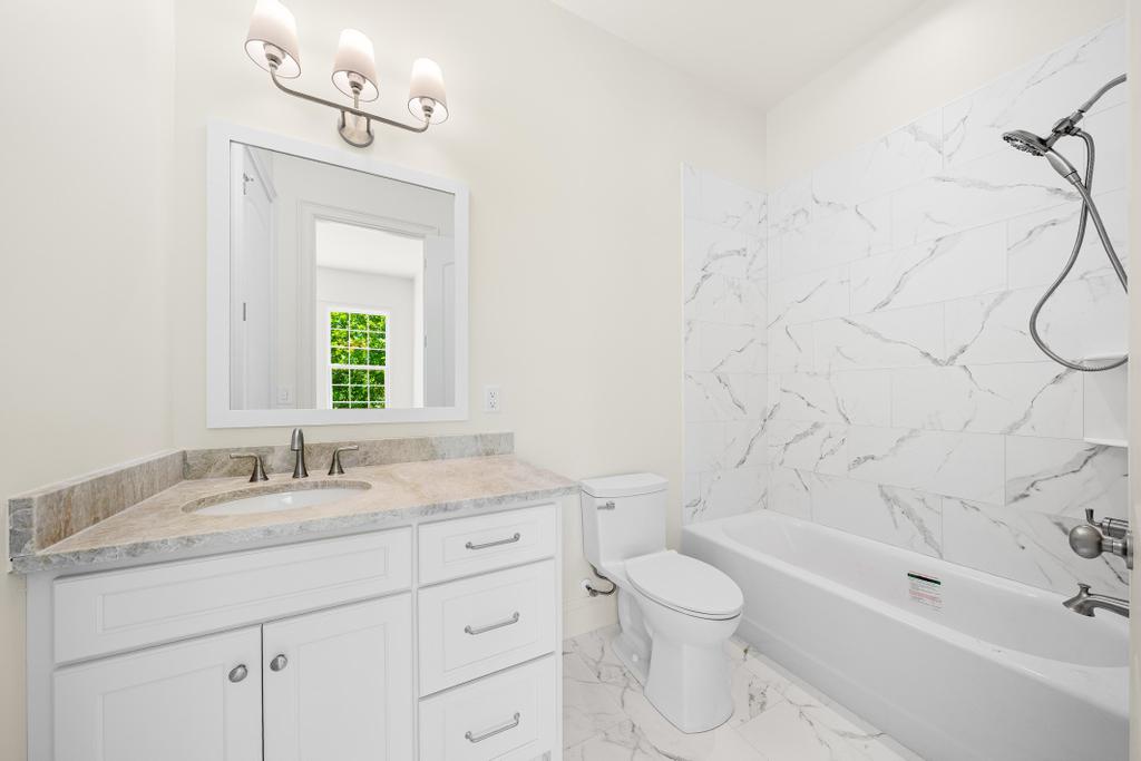 707 Vickery Street Extension Hartwell, GA 30643 - Photo 27 of 50 A well-appointed bathroom features a single vanity with stone counters and a shower-tub combination.