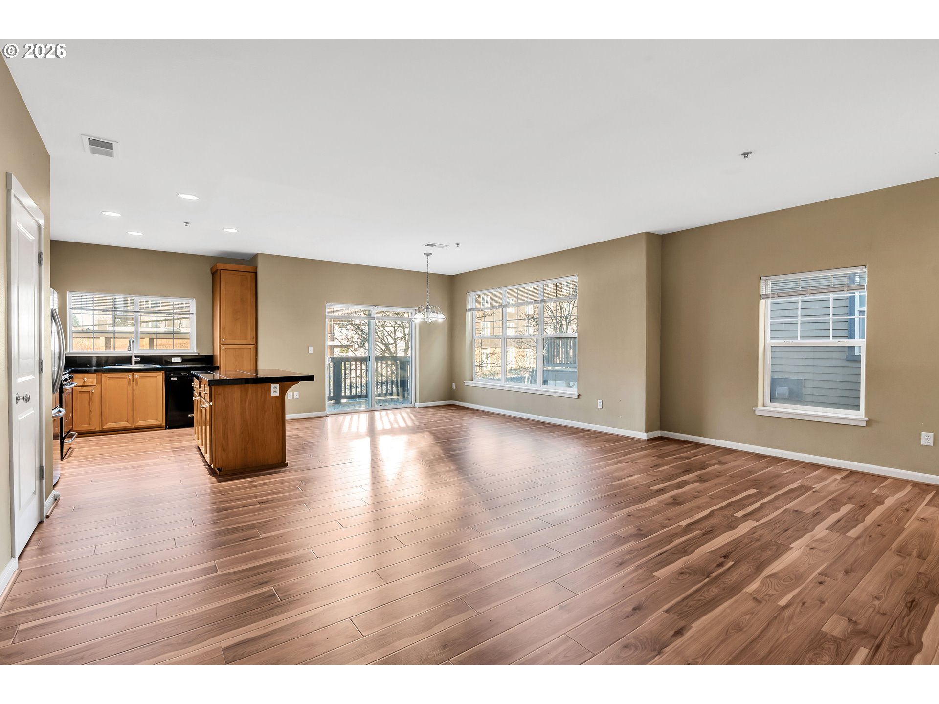 1000 Southwest 170th Avenue, Unit 201 Beaverton, OR 97003 - Photo 5 of 37 a view of an empty room with wooden floor and a kitchen