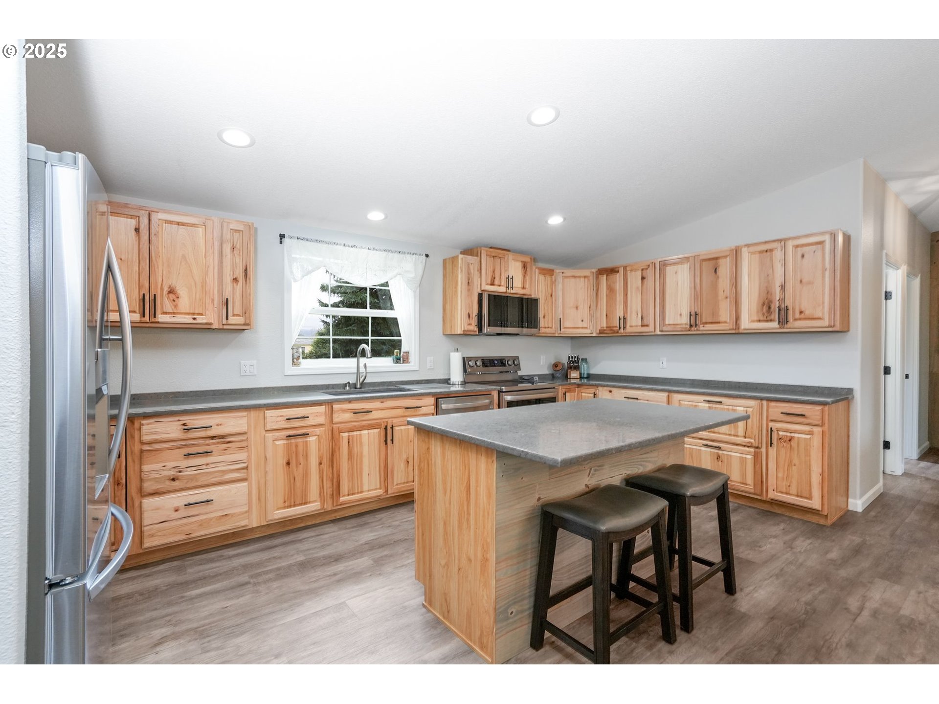 40219 North Dogwood Road Mill City, OR 97360 - Photo 12 of 47 a kitchen with kitchen island granite countertop wooden cabinets and white appliances