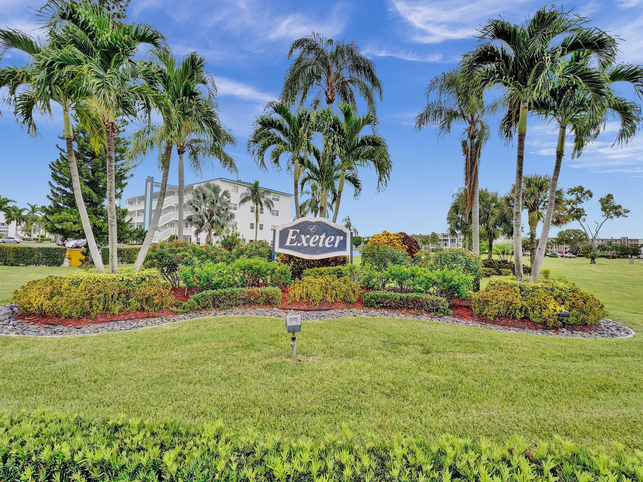 1031 Exeter, Unit 1031 Boca Raton, FL 33434 - Photo 1 of 24 a view of a swimming pool with a table and chairs potted plants and large tree
