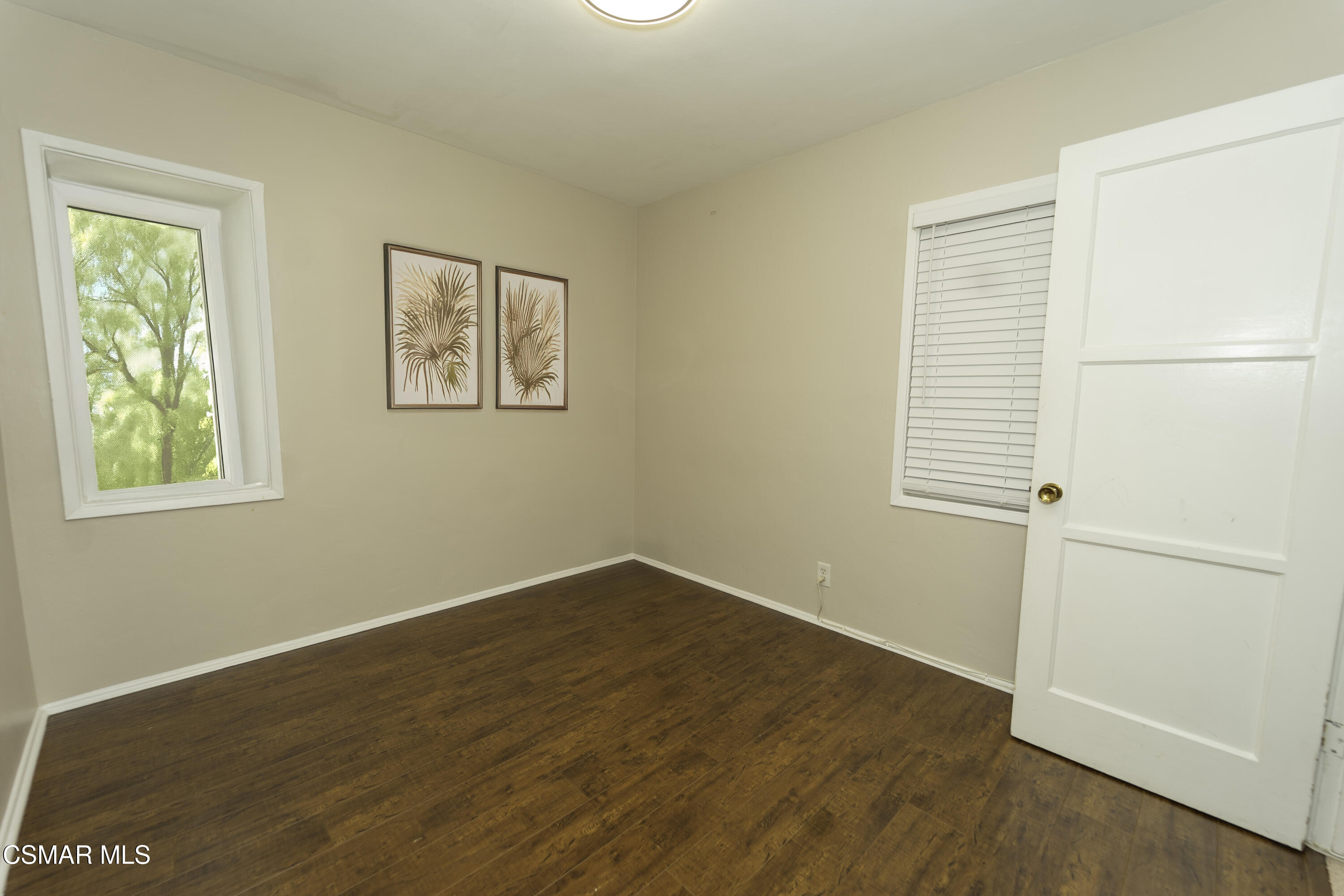 5834 Balcom Avenue Encino, CA 91316 - Photo 5 of 10 an empty room with wooden floor and windows