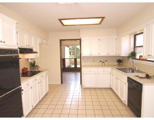 7238 Pepper Ridge Road Corpus Christi, TX 78413 - Photo 4 of 7 a kitchen with a sink dishwasher stove and white cabinets with wooden floor