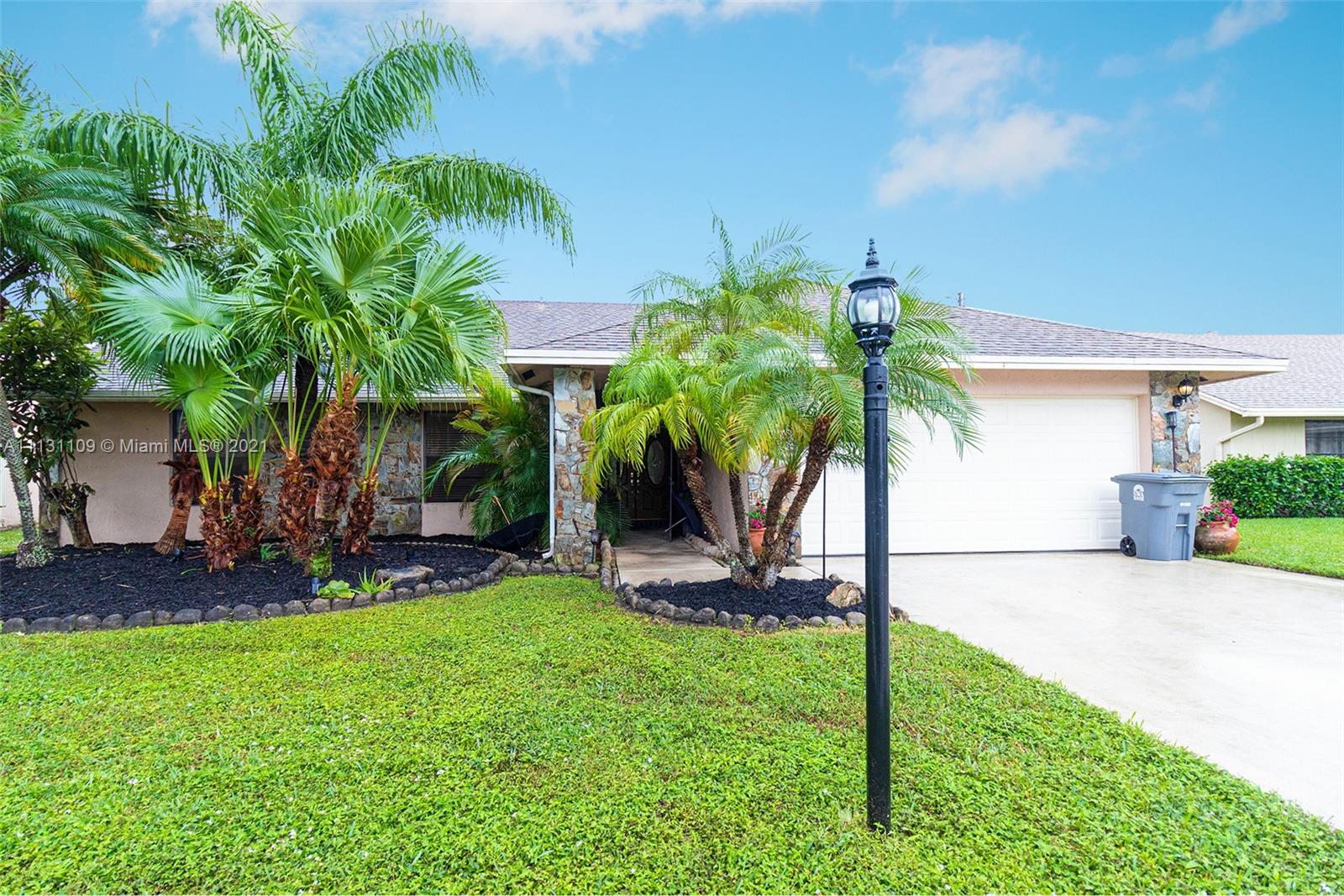 9248 Neptunes Basin Court Boca Raton, FL 33434 - Photo 1 of 34 a view of a house with a yard and palm trees