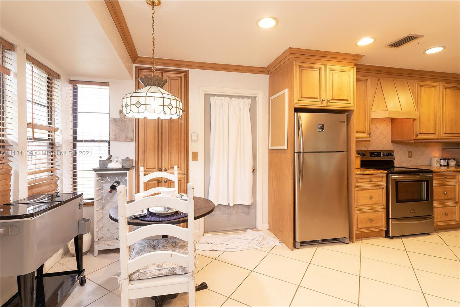 9248 Neptunes Basin Court Boca Raton, FL 33434 - Photo 16 of 34 a kitchen with stainless steel appliances a refrigerator a stove a sink and a dining table with wooden floor