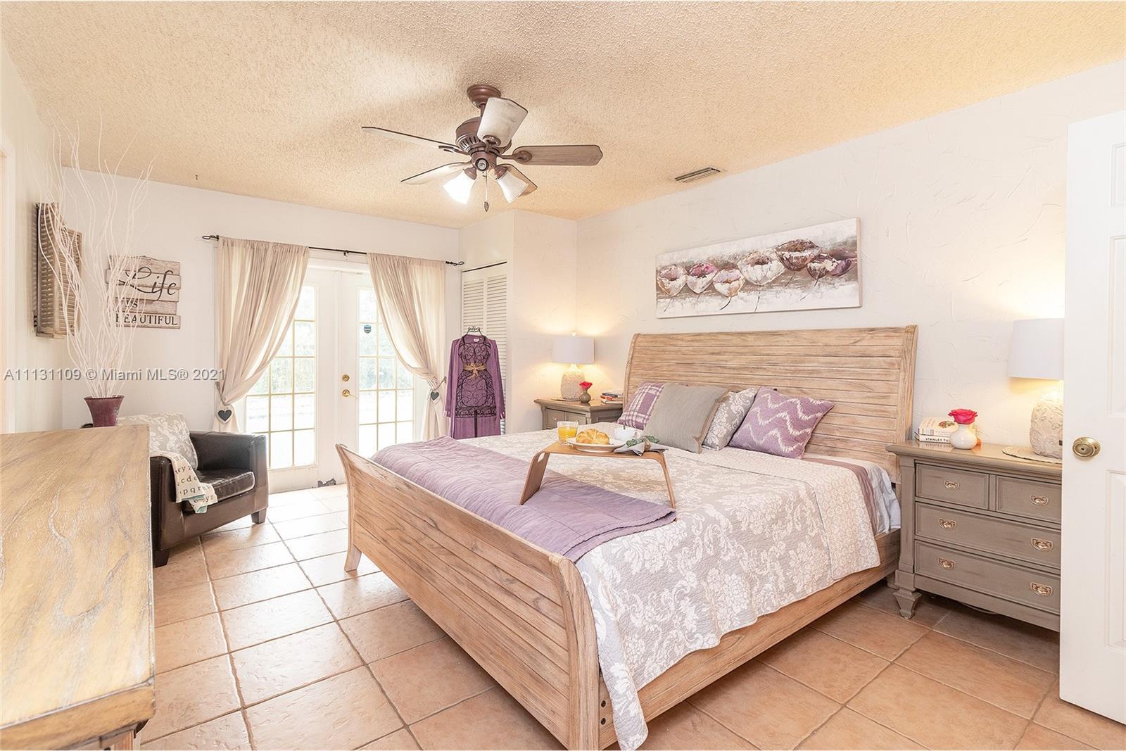 9248 Neptunes Basin Court Boca Raton, FL 33434 - Photo 22 of 34 a bedroom with a bed a couch and a chandelier