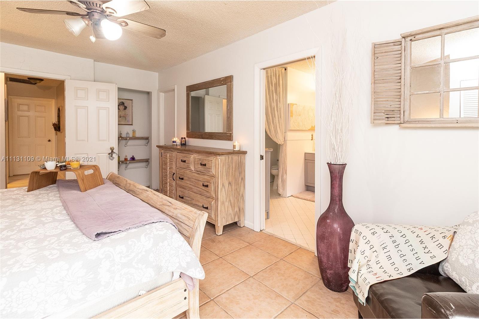 9248 Neptunes Basin Court Boca Raton, FL 33434 - Photo 24 of 34 a spacious bedroom with a bed and wooden floor