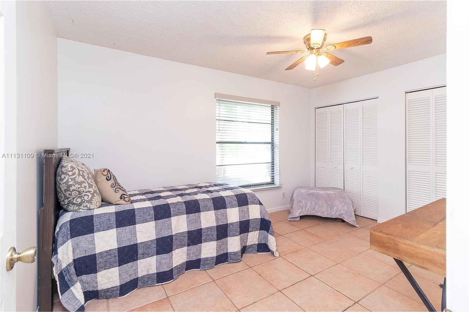9248 Neptunes Basin Court Boca Raton, FL 33434 - Photo 32 of 34 a bedroom with a bed and a chandelier